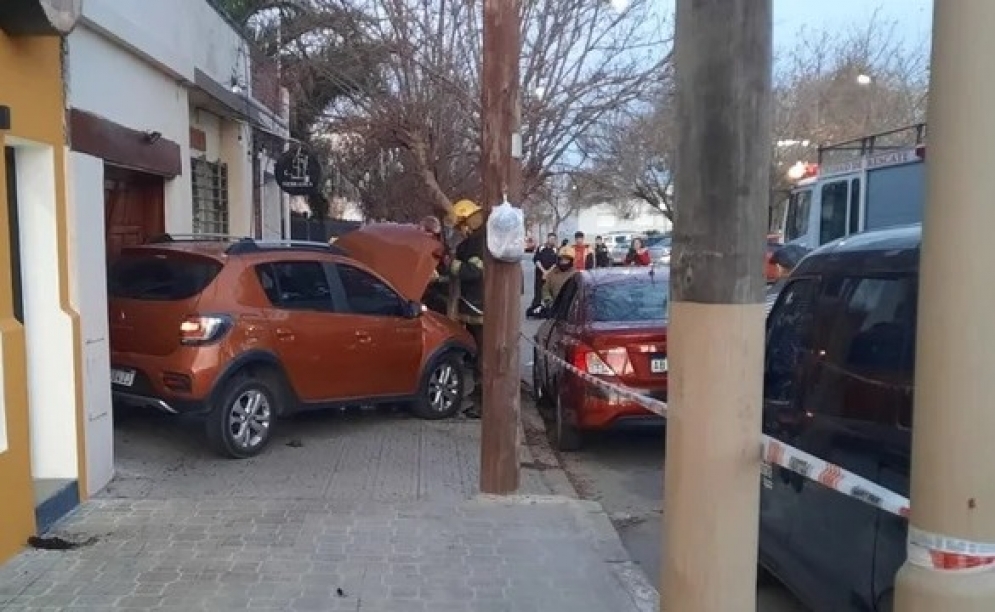 Accidente : auto incrustado entre un garaje y un árbol
